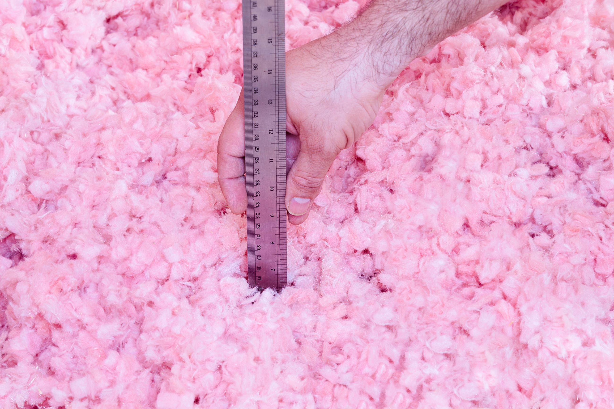 Image of a ruler demonstrating the height of the insulation in the home's attic